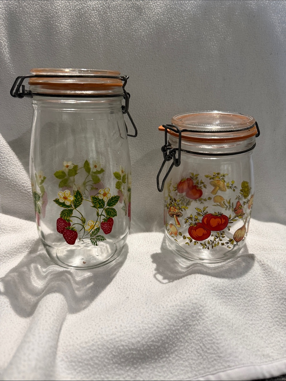Vintage Glass Pantry Jars with Orange Lids and Red Fruit Motifs
